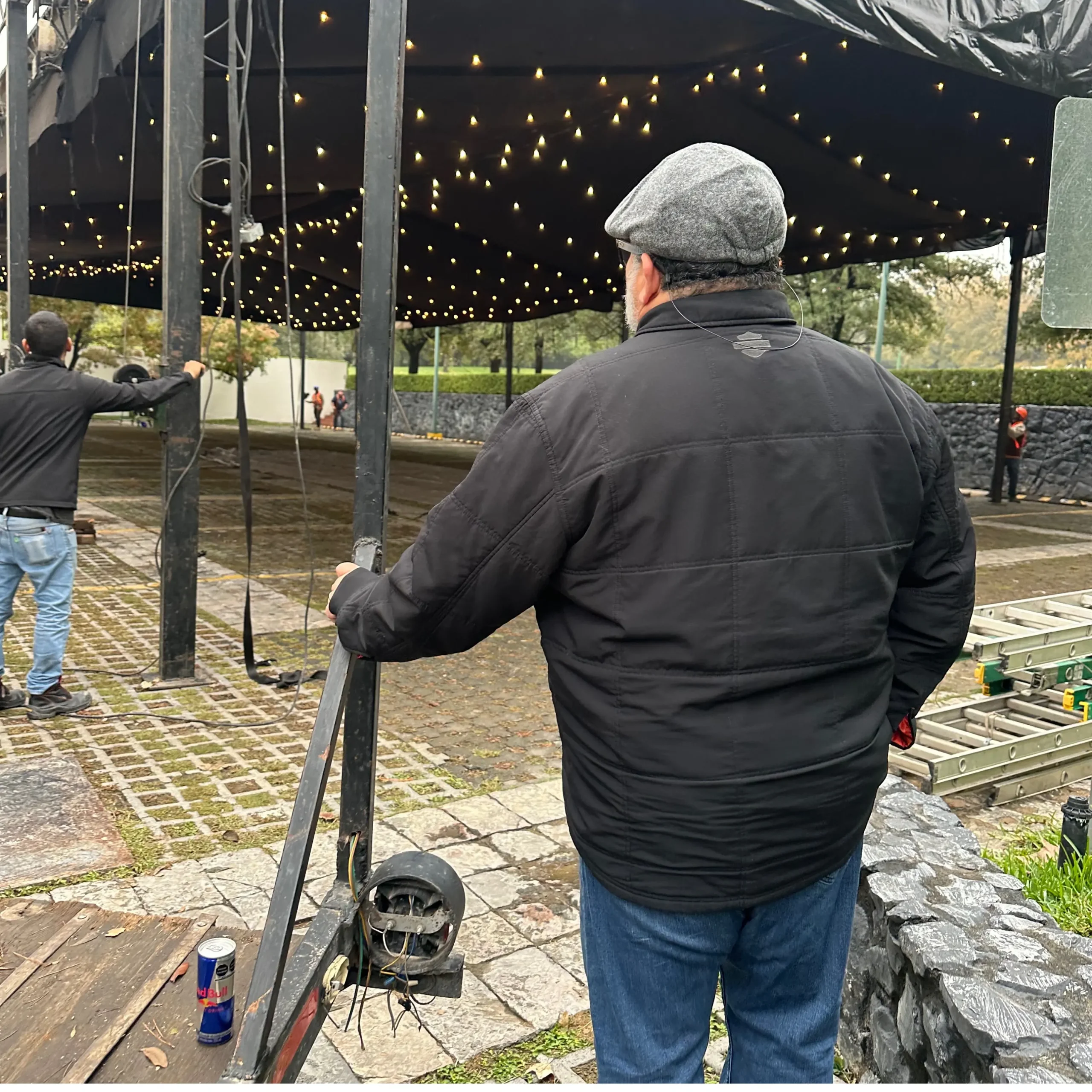 Coordinador supervisando montaje de evento empresarial al aire libre.